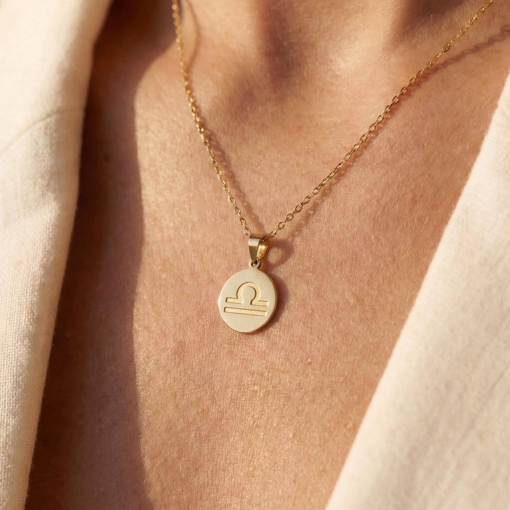 Minimalist round Libra zodiac coin necklace on model, dainty astrology pendant gift for September and October birthdays, celestial jewelry style