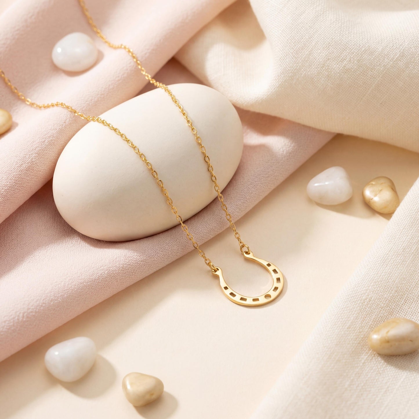 Dainty 14K gold horseshoe necklace worn delicately on a woman's neck, minimalist lucky charm pendant jewelry ideal for everyday wear and thoughtful Mother's day gift.