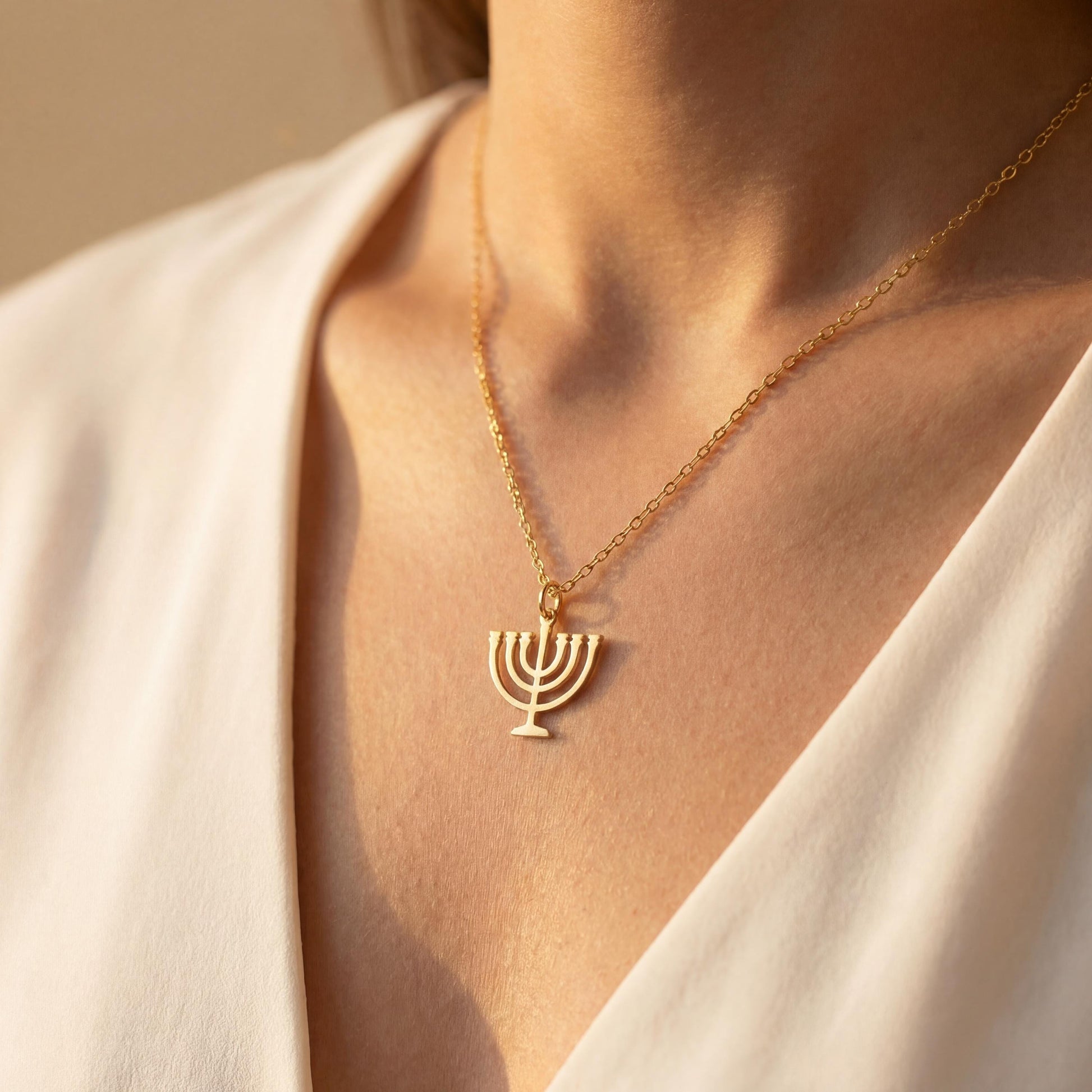 Dainty 14K gold plated minimalist Menorah necklace worn by a woman, elegant Jewish Judaica pendant jewelry ideal for Mother's Day or Bat Mitzvah gift.