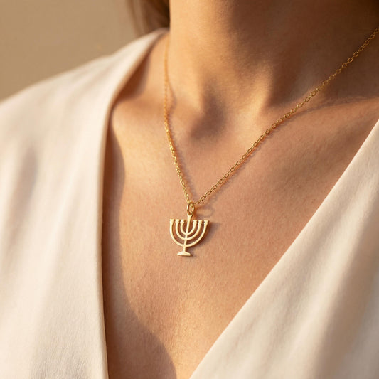 Dainty 14K gold plated minimalist Menorah necklace worn by a woman, elegant Jewish Judaica pendant jewelry ideal for Mother's Day or Bat Mitzvah gift.