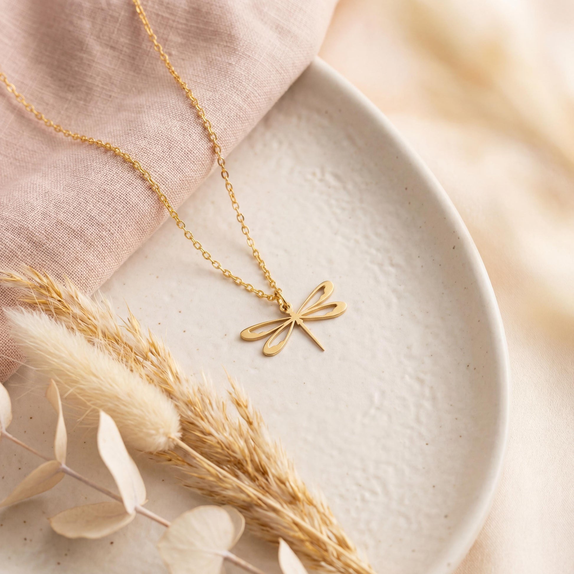 Minimalist 14K gold plated dragonfly necklace worn by a blonde woman, delicate insect pendant resting on collarbone, elegant Mother's Day jewelry gift idea.