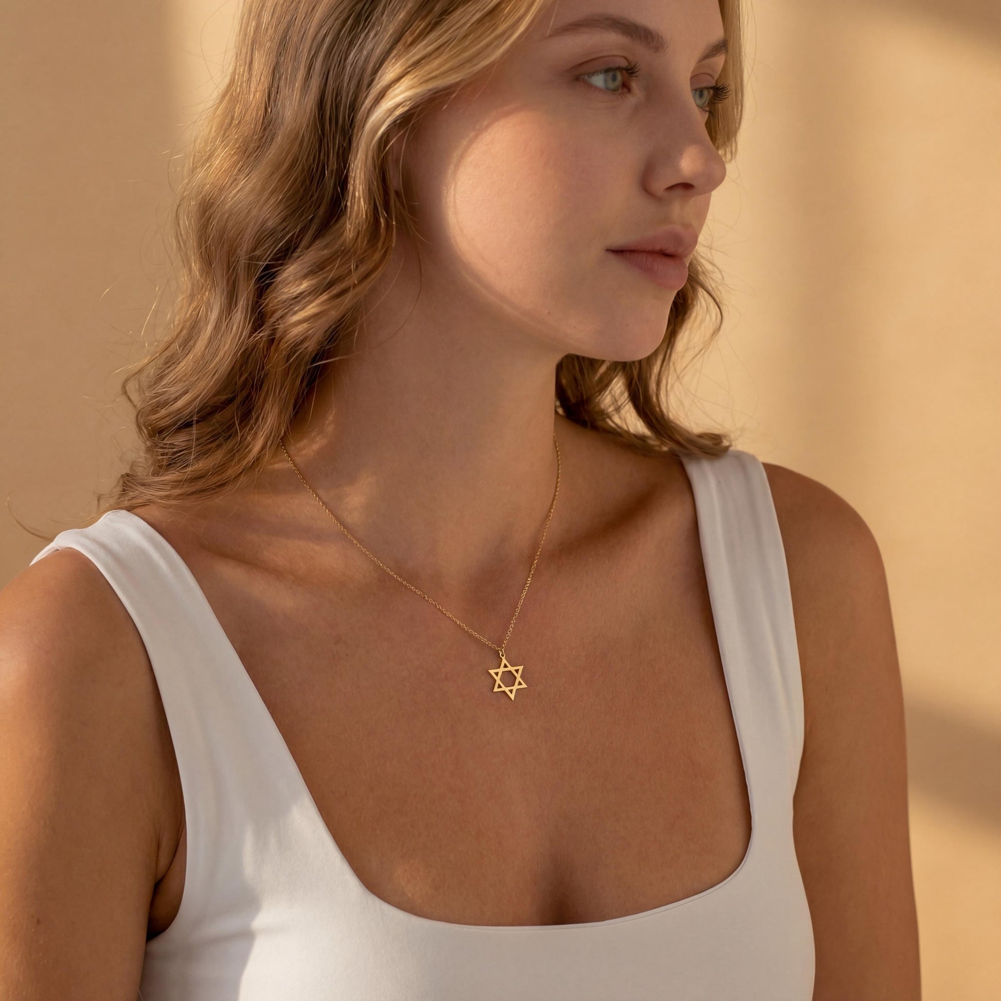 Minimalist gold Star of David pendant necklace on a woman's neck, dainty Magen David Jewish jewelry gift for Bat Mitzvah and Mother's Day.