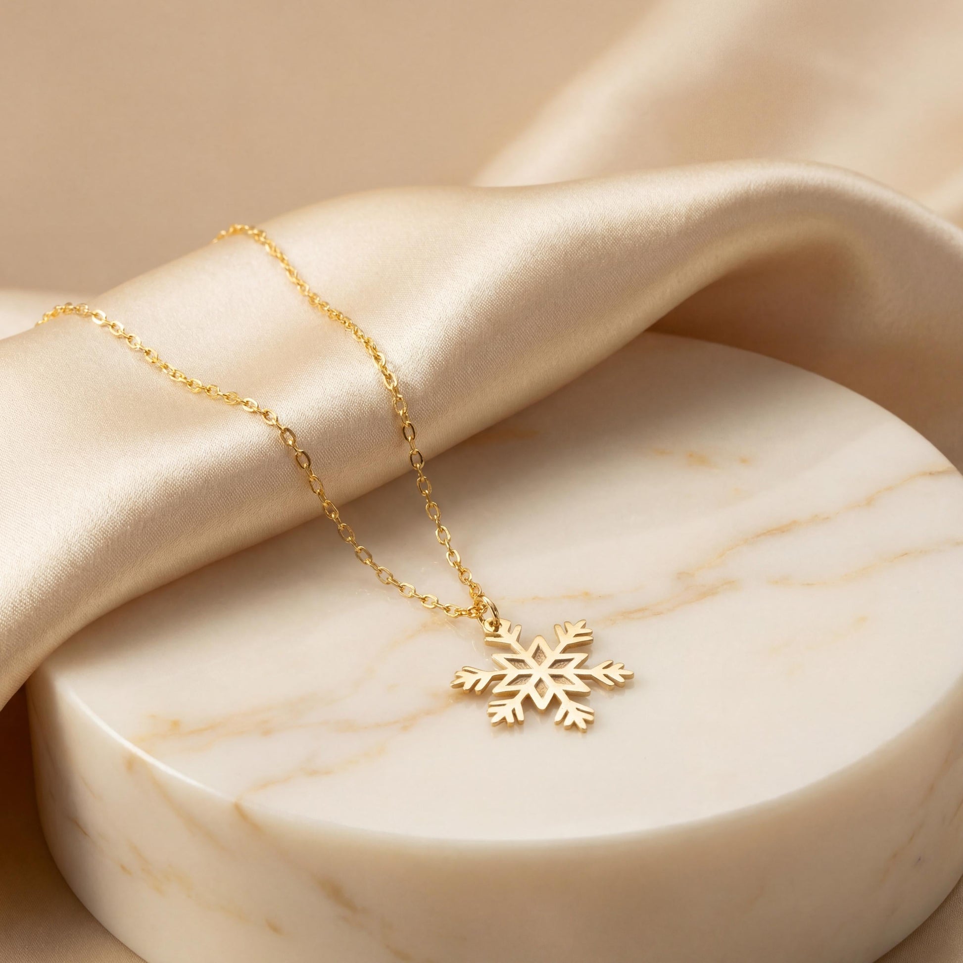 Dainty 14K gold plated snowflake pendant necklace resting elegantly on a woman's collarbone, showing a minimalist geometric jewelry design perfect for a unique Mother's Day gift or layered everyday wear.