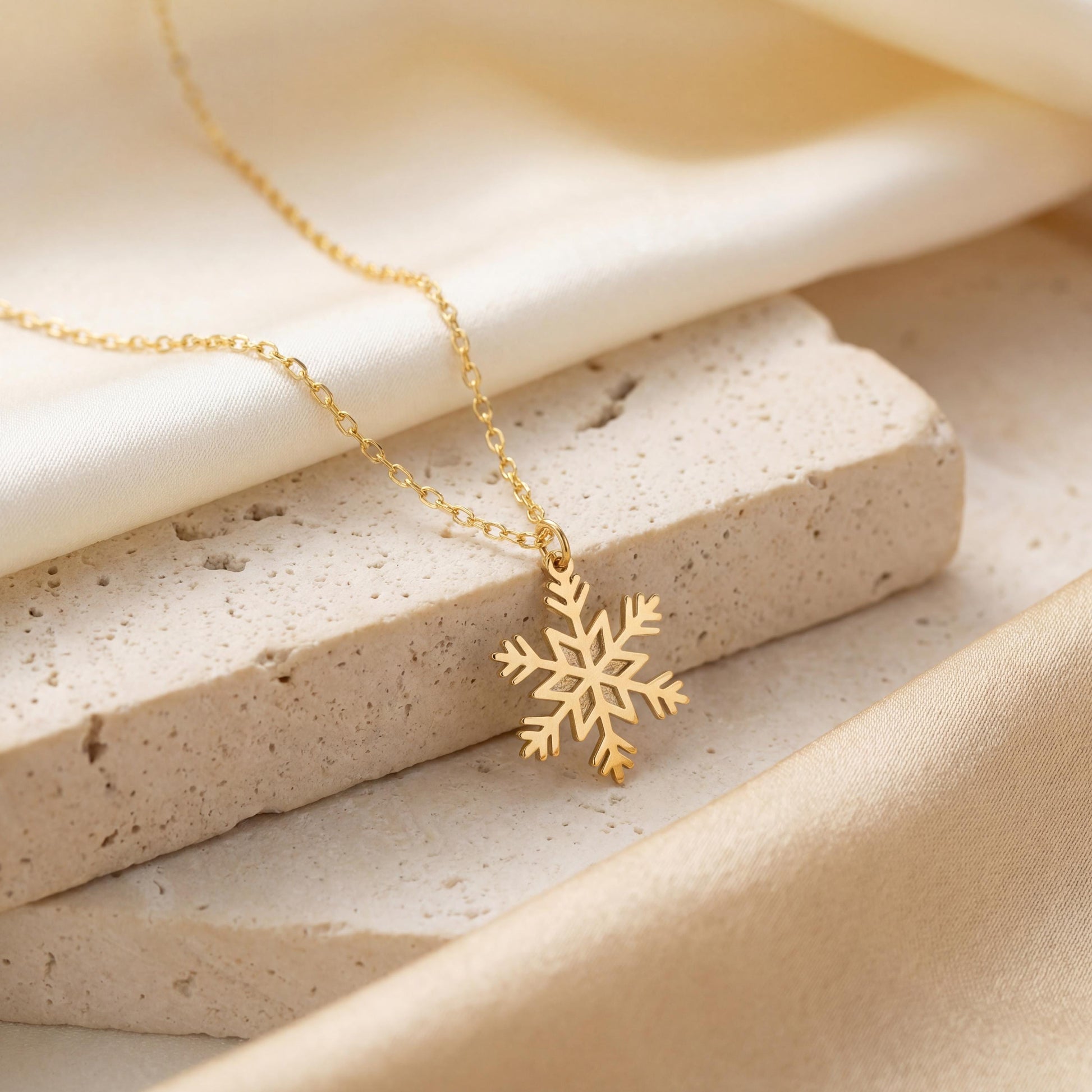 Dainty 14K gold plated snowflake pendant necklace resting elegantly on a woman's collarbone, showing a minimalist geometric jewelry design perfect for a unique Mother's Day gift or layered everyday wear.