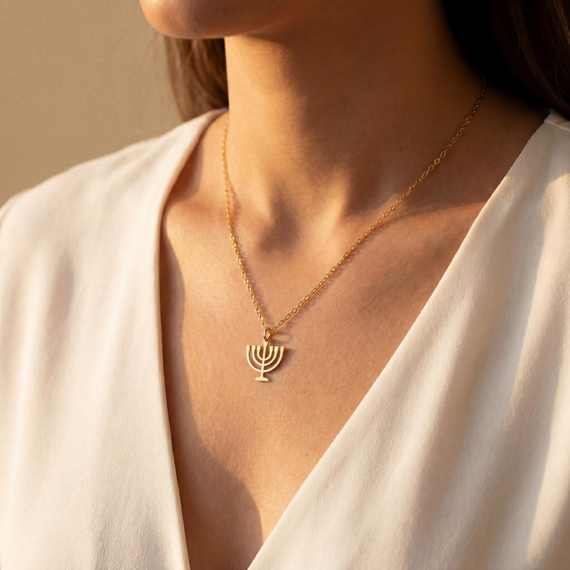 Dainty 14K gold plated minimalist Menorah necklace worn by a woman, elegant Jewish Judaica pendant jewelry ideal for Mother's Day or Bat Mitzvah gift.