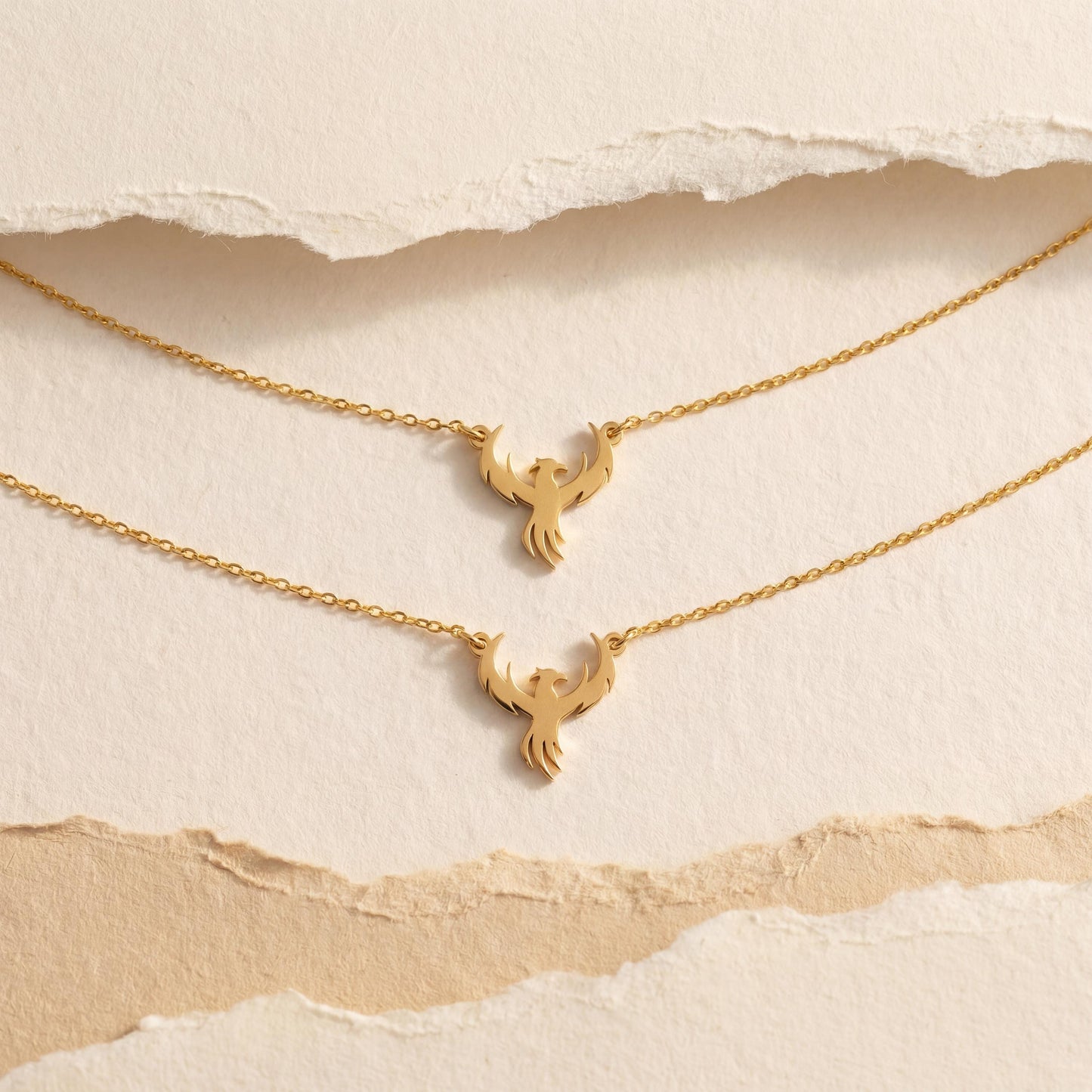 Minimalist gold phoenix pendant necklace worn on a woman's collarbone in warm sunlight, symbolizing rebirth and strength, ideal for Mothers Day gifting